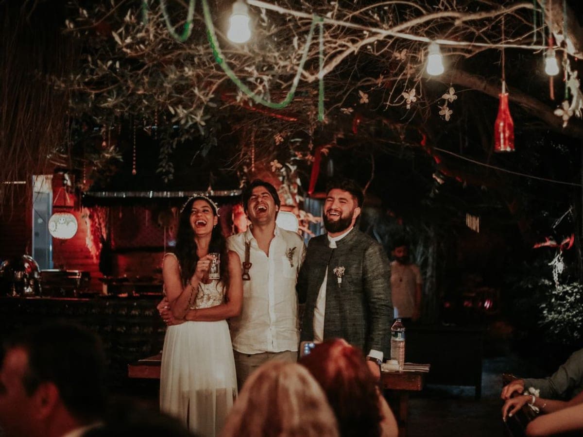 Friends laughing during a wedding reception.