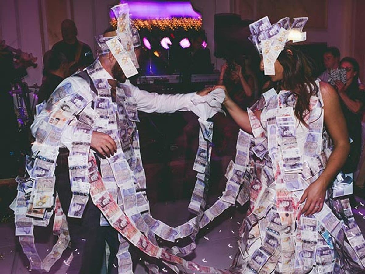 Wedding guests pinning money during a Greek wedding money dance.